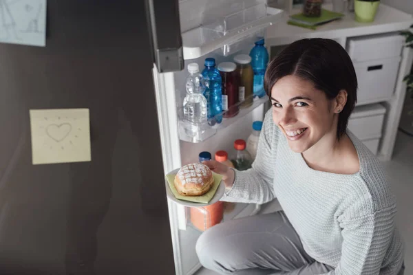 Женщина достает кондитерскую из холодильника — стоковое фото