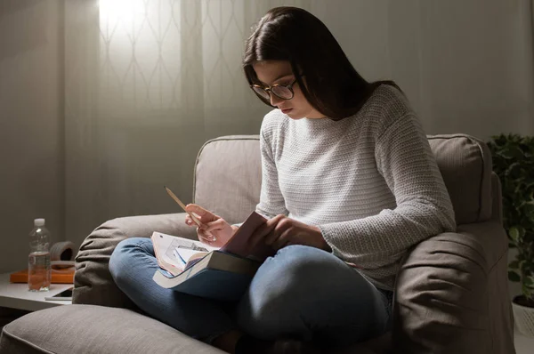 女孩坐在扶手椅里拿着本书 — 图库照片