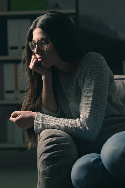 Femme déprimée assise sur le canapé à la maison — Photo