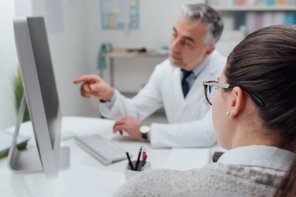 Arzt zeigt Patientin Krankenakten — Stockfoto