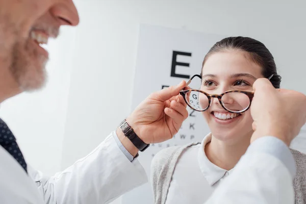 Ophthalmologist putting glasses on woman — Stock Photo, Image