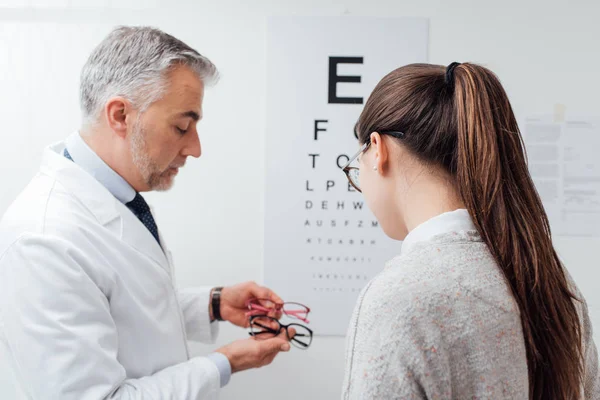 Woman choosing pair of glasses — Stock Photo, Image