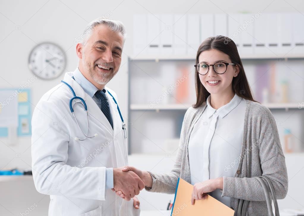 female patient shaking hand of doctor