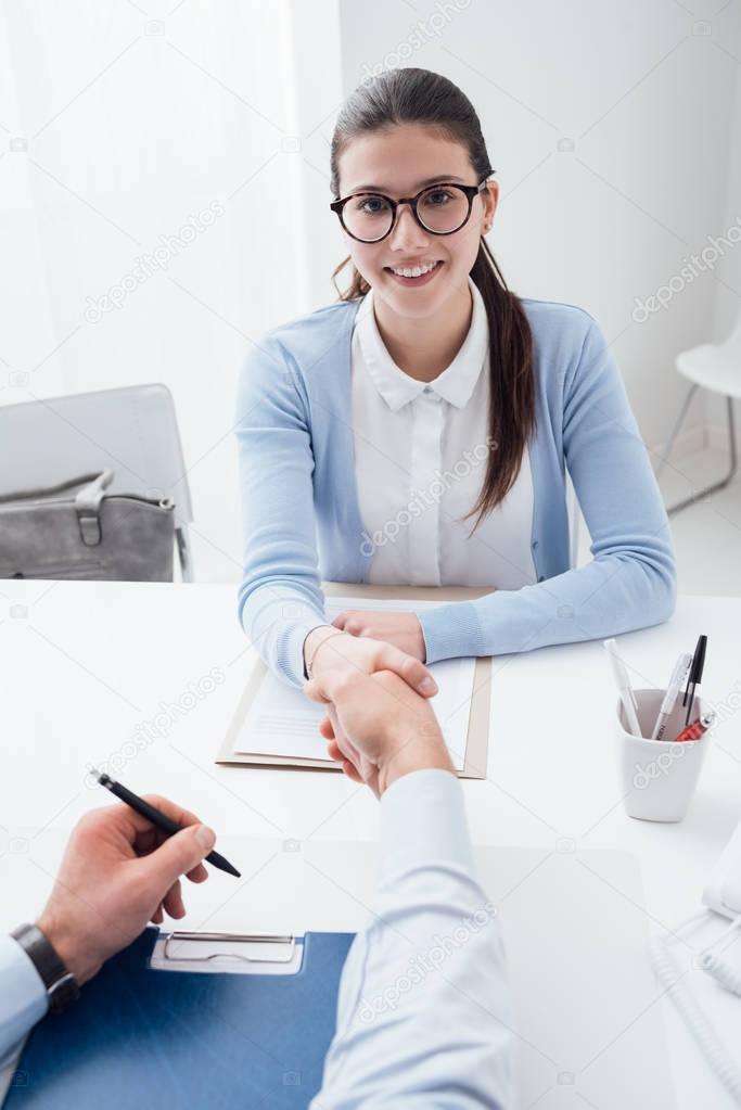 examiner shaking hand of smart woman