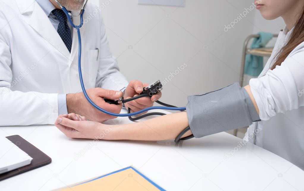 Doctor checking blood pressure of patient