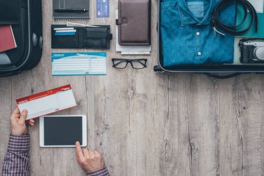 Tablet ve rezervasyon uçuşlar kullanan adam