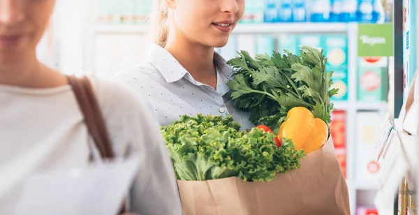 Jonge vrouwen winkelen bij de supermarkt — Stockfoto