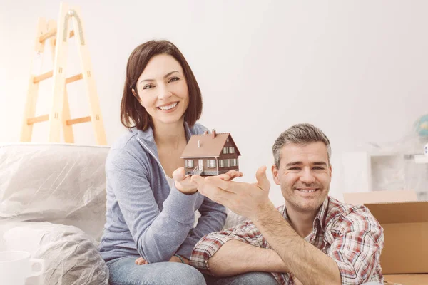 Smiling couple holding model house — Stock Photo, Image