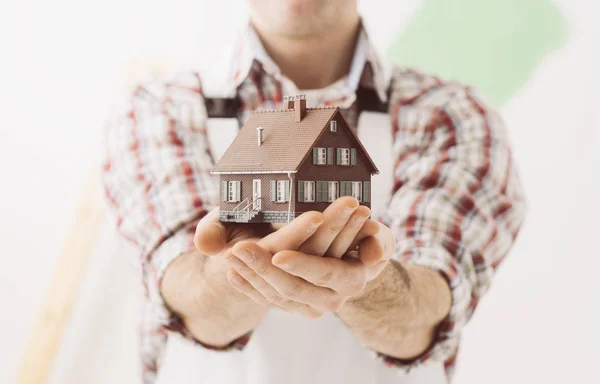 Empreiteiro de construção segurando casa modelo — Fotografia de Stock