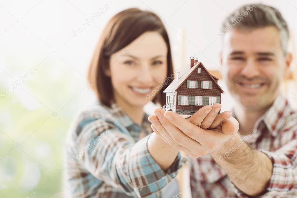 Happy couple holding dream house
