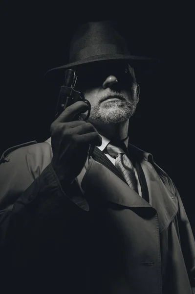 Detective holding gun in dark — Stock Photo, Image