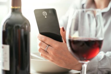 Restoranda şarap app kullanan kadın