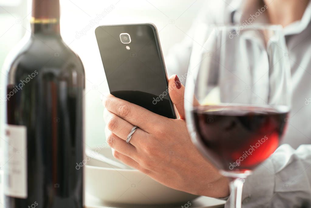 Woman using wine app at restaurant