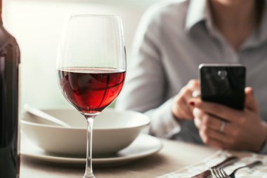Restoranda bir akıllı telefon kullanan kadın