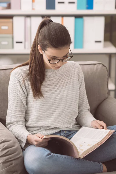 Giovane donna in occhiali che studia a casa — Foto Stock