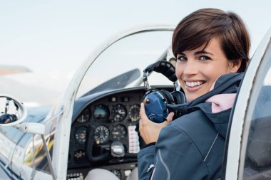 Uçak kokpit içinde gülümseyen kadın pilot