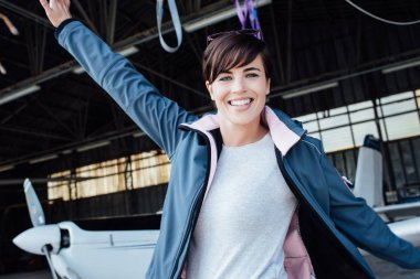 Hangarda poz neşeli kadın pilotu