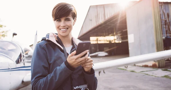 Lächelnde junge Frau auf Flugplatz — Stockfoto