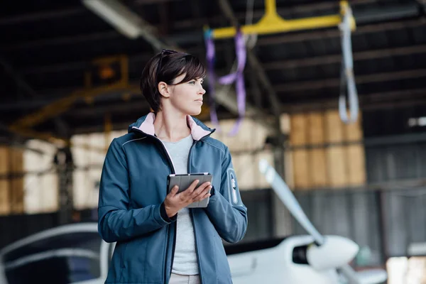 Kvinnliga pilot i hangar — Stockfoto