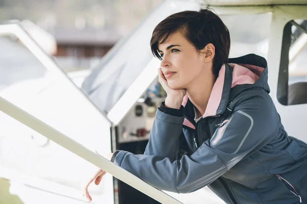 Pilota donna appoggiato sull'aereo — Foto Stock