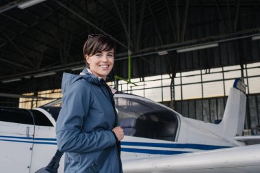 kadın pilotu Havaalanı hangarında poz