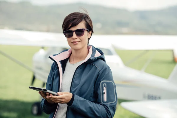 Pilote femelle se connectant avec tablette — Photo