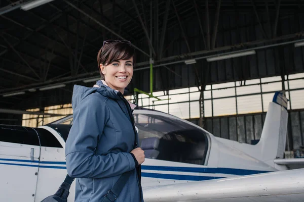kadın pilotu Havaalanı hangarında poz