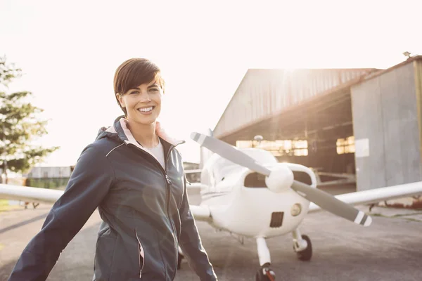 Lachende vrouw op luchthaven met vliegtuigen — Stockfoto