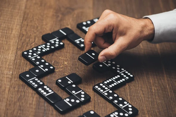 Uomo d'affari che gioca con il domino — Foto Stock