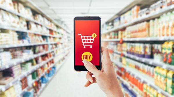 Vrouw doet boodschappen bij de supermarkt — Stockfoto