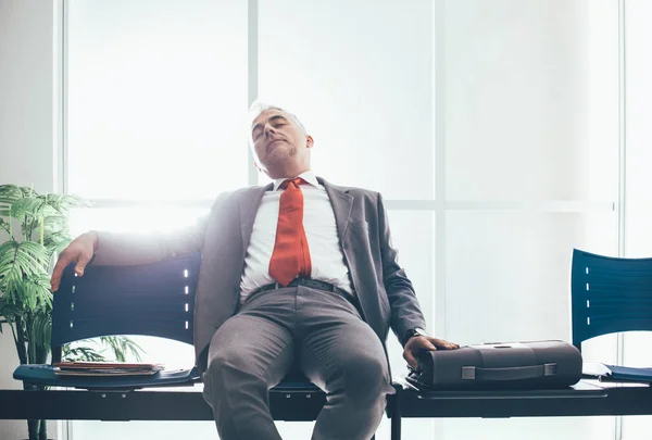 Trött affärsman sover i väntrum — Stockfoto