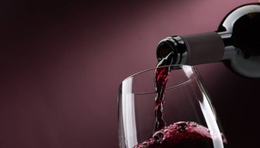Pouring red wine from bottle  clipart