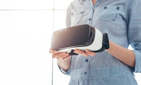 VR kulaklık tutan kadın