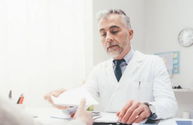 Doktor hastaya reçete yazıyor.