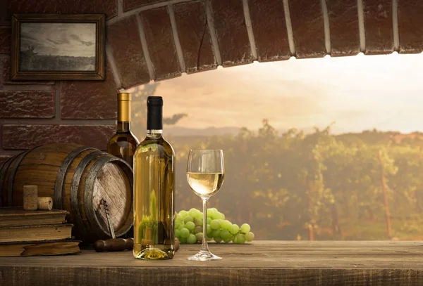 Wineglass and bottles next to window — Stock Photo, Image