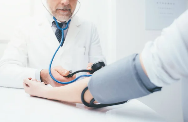 Médico verificando a pressão arterial — Fotografia de Stock