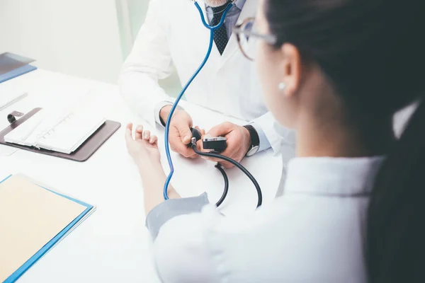 Médico verificando a pressão arterial do paciente — Fotografia de Stock