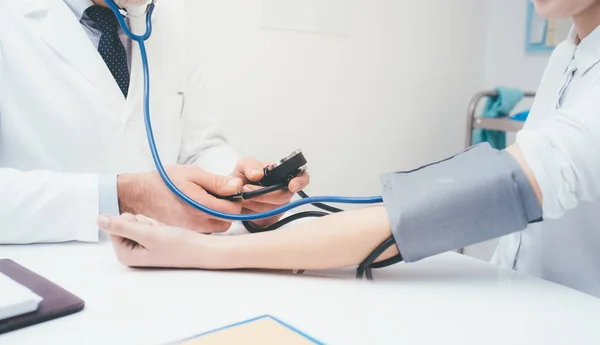 Médico verificando a pressão arterial — Fotografia de Stock