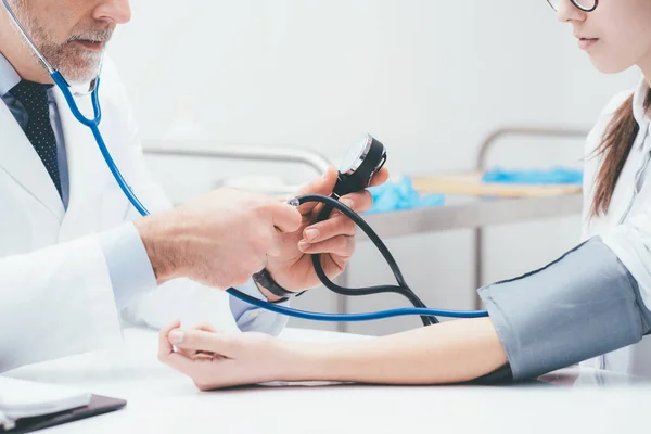 Médico control de la presión arterial del paciente —  Fotos de Stock