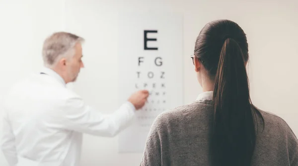 Woman reading eye chart — Stock Photo, Image