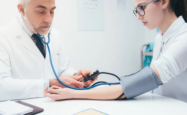 Médico verificando a pressão arterial do paciente — Fotografia de Stock