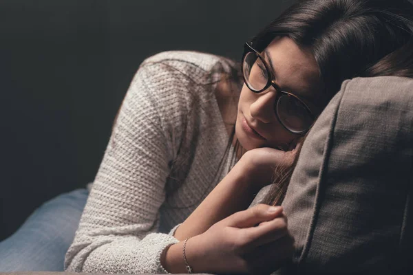 Sad woman sitting on couch — Stock Photo, Image