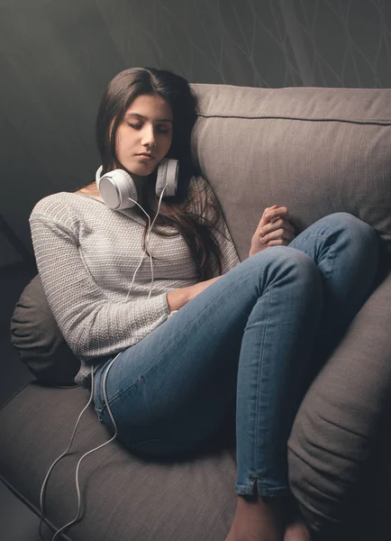 Dívka s sluchátka spaní na křeslo — Stock fotografie