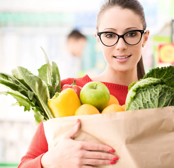 Молодая женщина покупает свежие овощи — стоковое фото