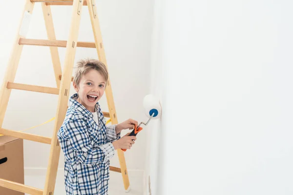 Gelukkig schattige jongen schilderen muur — Stockfoto