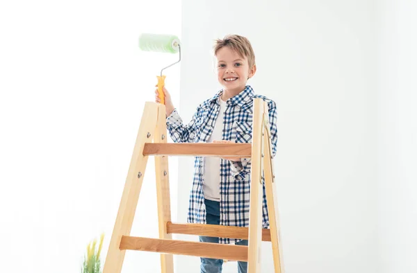 Lachende jongen staande op een ladder — Stockfoto