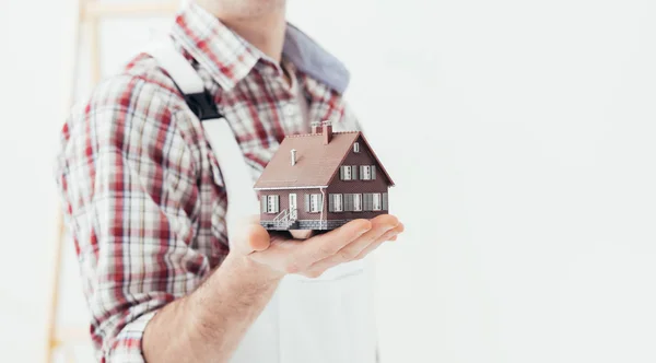 Building contractor holding model house — Stock Photo, Image