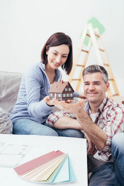 Couple holding model house together