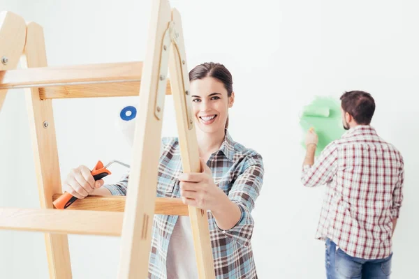 Jonge vrouw en man schilderen muren — Stockfoto