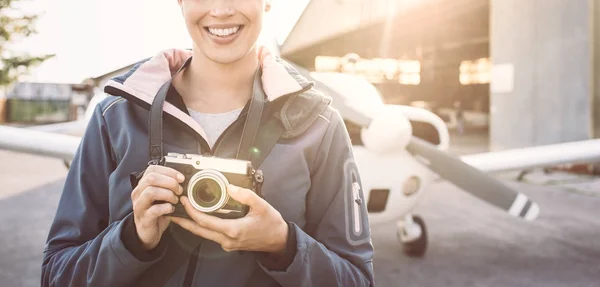 Jonge vrouwelijke fotograaf op luchthaven — Stockfoto